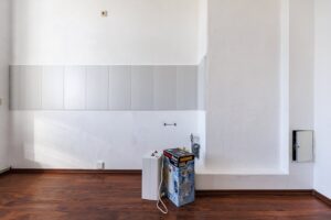 weiße Wand, weißer Fliesenspiegel, brauner Parkettfußboden