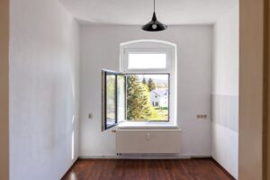 weiße Wände, weißer Fliesenspiegel, weißes Fenster, brauner Parkettfußboden