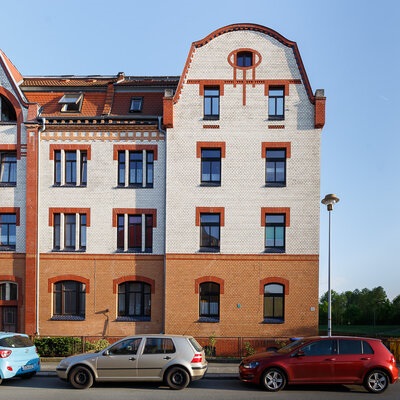 weiße Fassade, brauner Sockel, Fensterfront
