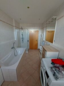 Fußboden- und Wandfliesen. Bad mit Badewanne, Waschmaschinenanschluss