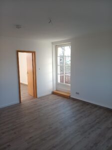 brauner Parkettfußboden, weiße Wände, weiße Balkontür, braune Innentür