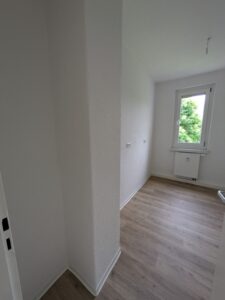 Kinderzimmer der Wohnung 40877.1.2 in der Schrammstraße 37 in Zittau mit weißen Wänden und eichefarbenen Fußboden