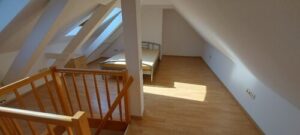brauner Laminatboden, weiße Wände, Säulen, Dachschräge, Fenster, Bett