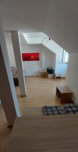 brauner Laminatboden, weiße Wände, Fenster, Dachschrägen, Sitzecke, Schränke, Bild