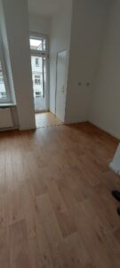 brauner Laminatboden, weiße Wände, weiße Tür in Speisekammer, Balkontür weiß