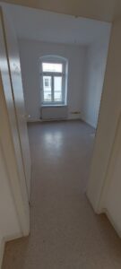 weiße Wände, weiße Türen, Fenster, brauner Linoleumbelag