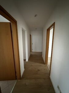 braune Türe, braune Laminat und weiße Wände