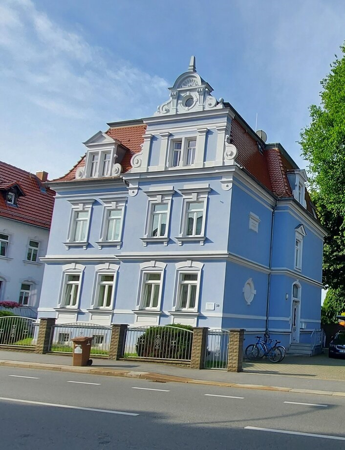blaues Villenhaus, vier Fenster pro Etage, 3 Etagen, blaue Fassade, rotes Dach