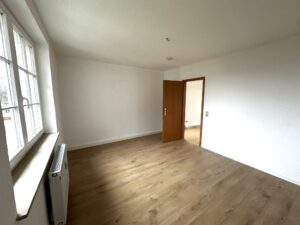 braune Laminat und weiße Wände sowie weiße Holzfenster