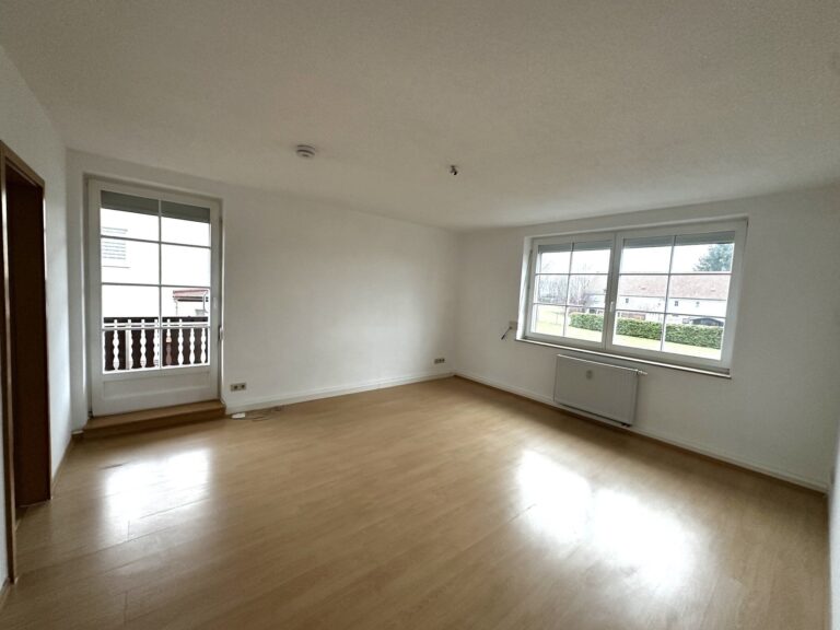 braune Laminat, weiße Wände und weiße Fenster sowie Balkontür