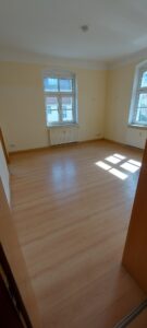 brauner Laminatfußbodenbelag, braune Holztür, gelb gestrichene Wände, weiße Kunststofffenster